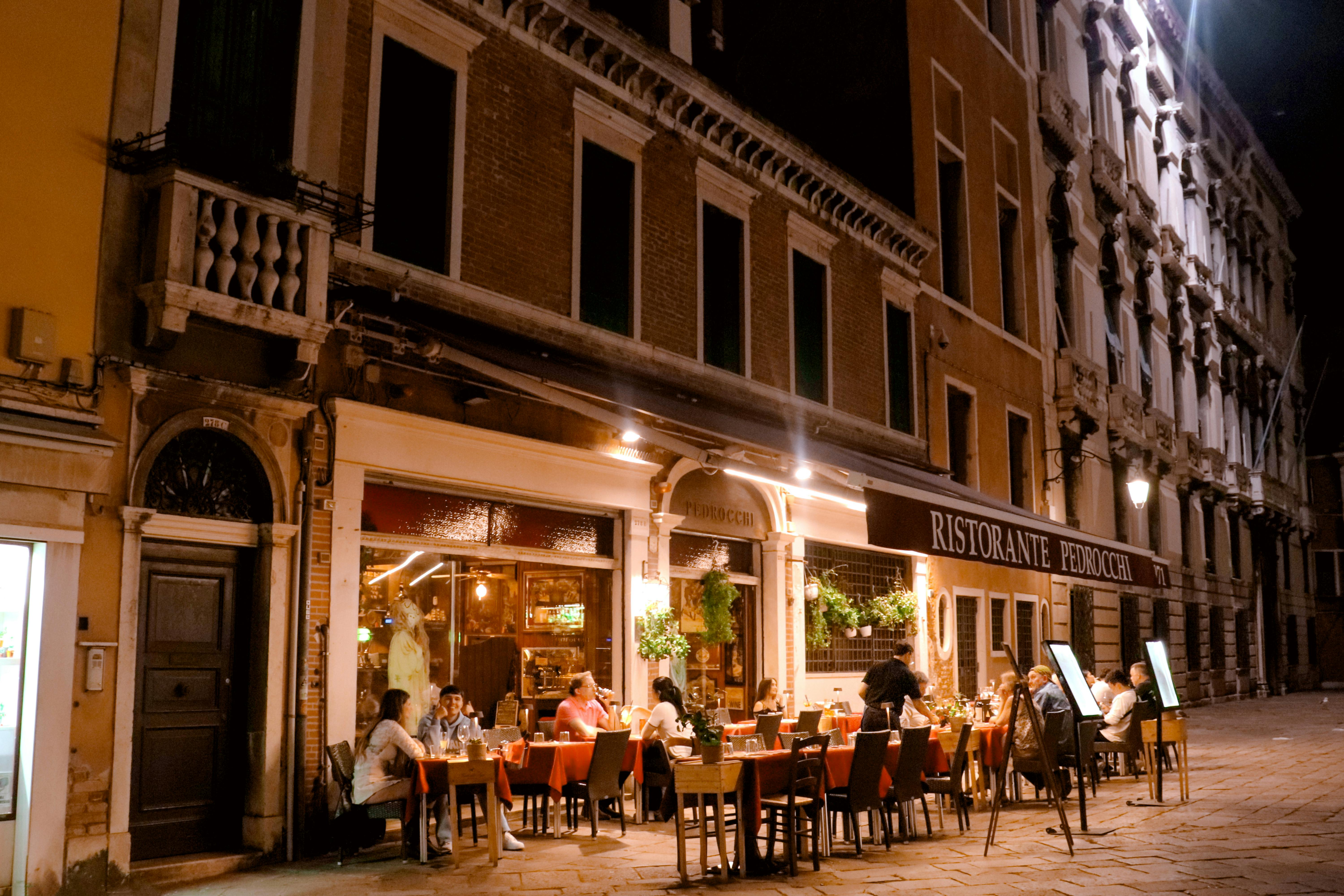 Charming evening ambiance of diners enjoying a meal at Ristorante Pedrocchi in Venice, Italy.