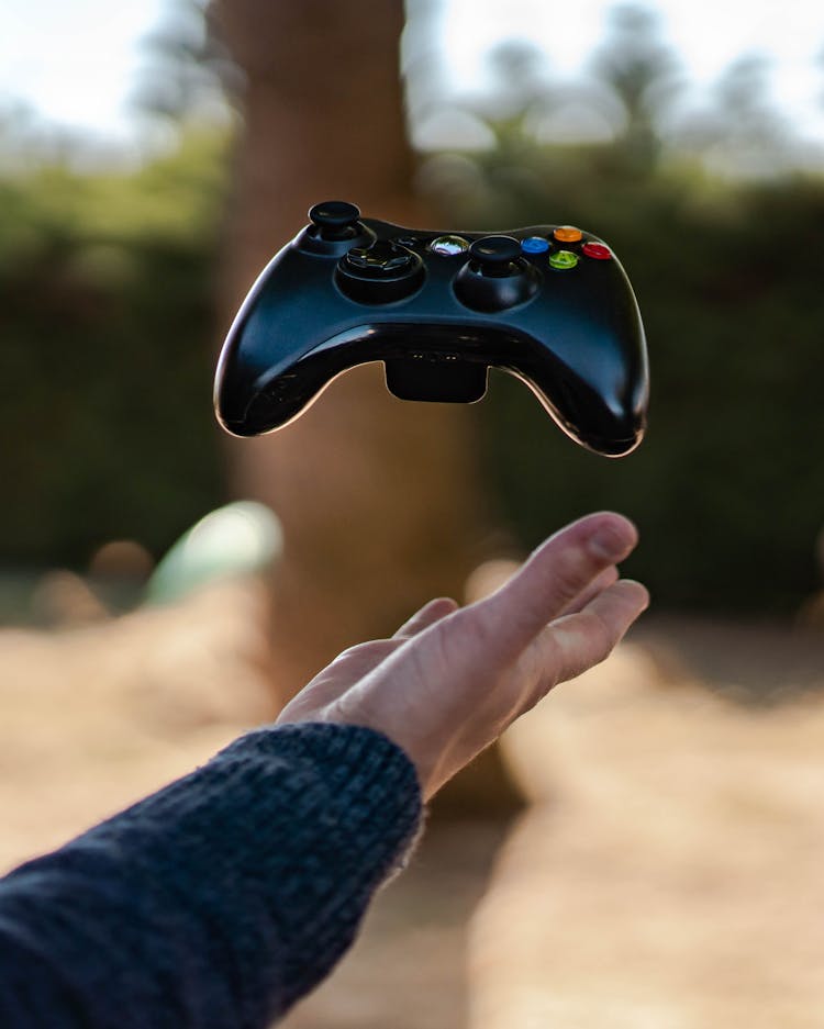 Photo Of Person Catching Gamepad