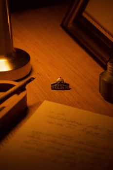 A warmly lit vintage desk with a pen holder, notepad, and unique trinket.