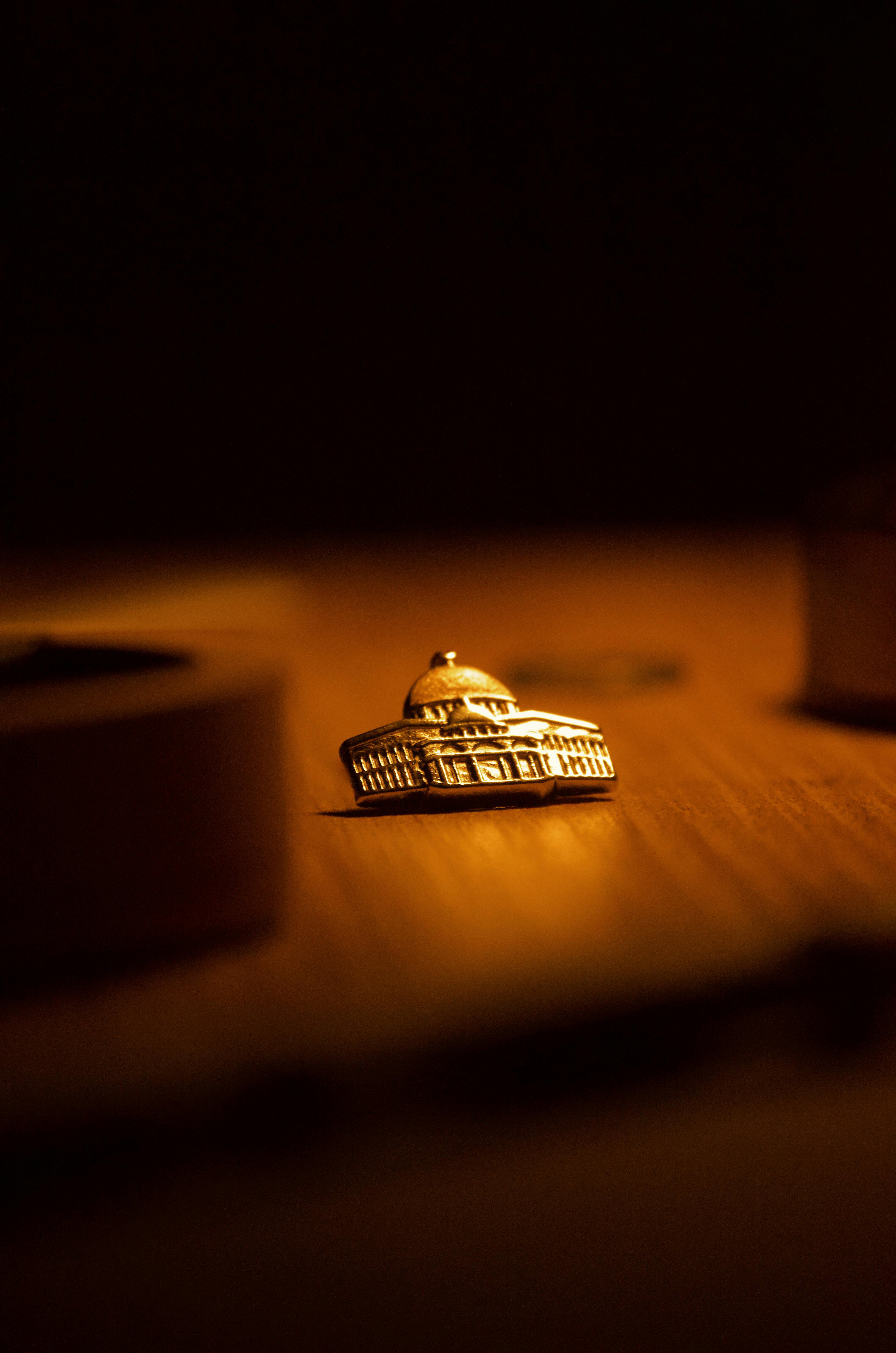 Gratis Un edificio a cupola in miniatura illuminato da luci calde, posto su una superficie di legno, che evoca un'atmosfera accogliente. Foto a disposizione