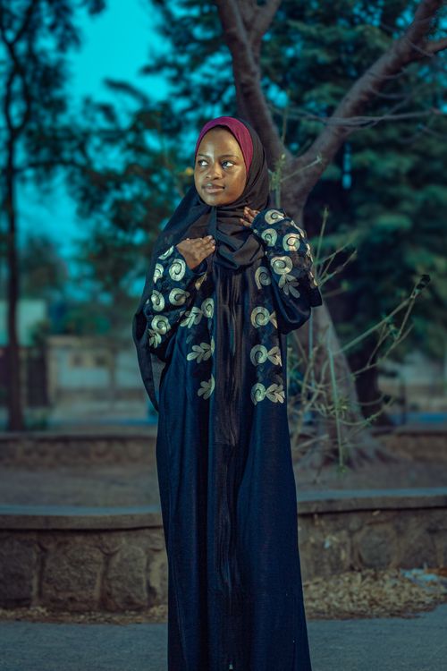 Free Portrait of a young woman in traditional attire standing outdoors in Zaria, Nigeria. Stock Photo