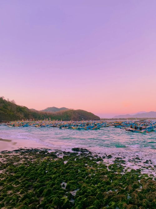 Free Calm evening at a beach with boats anchored under a beautiful twilight sky. Stock Photo