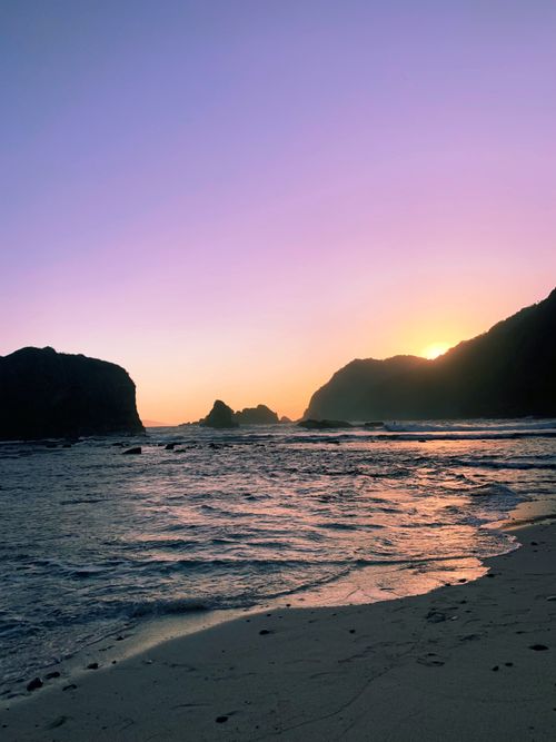 Free A tranquil beach scene at sunset with stunning twilight colors over the ocean waves. Stock Photo