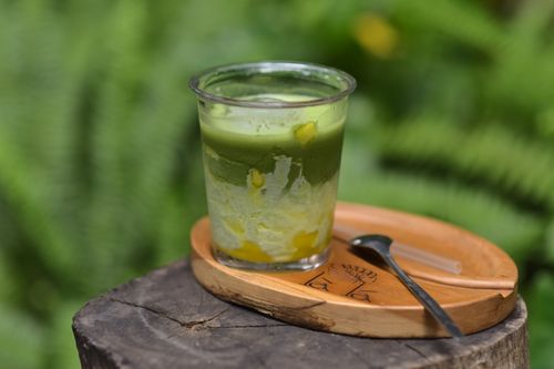 Free A delicious matcha and mango dessert in a clear cup outside. Perfect for summer. Stock Photo