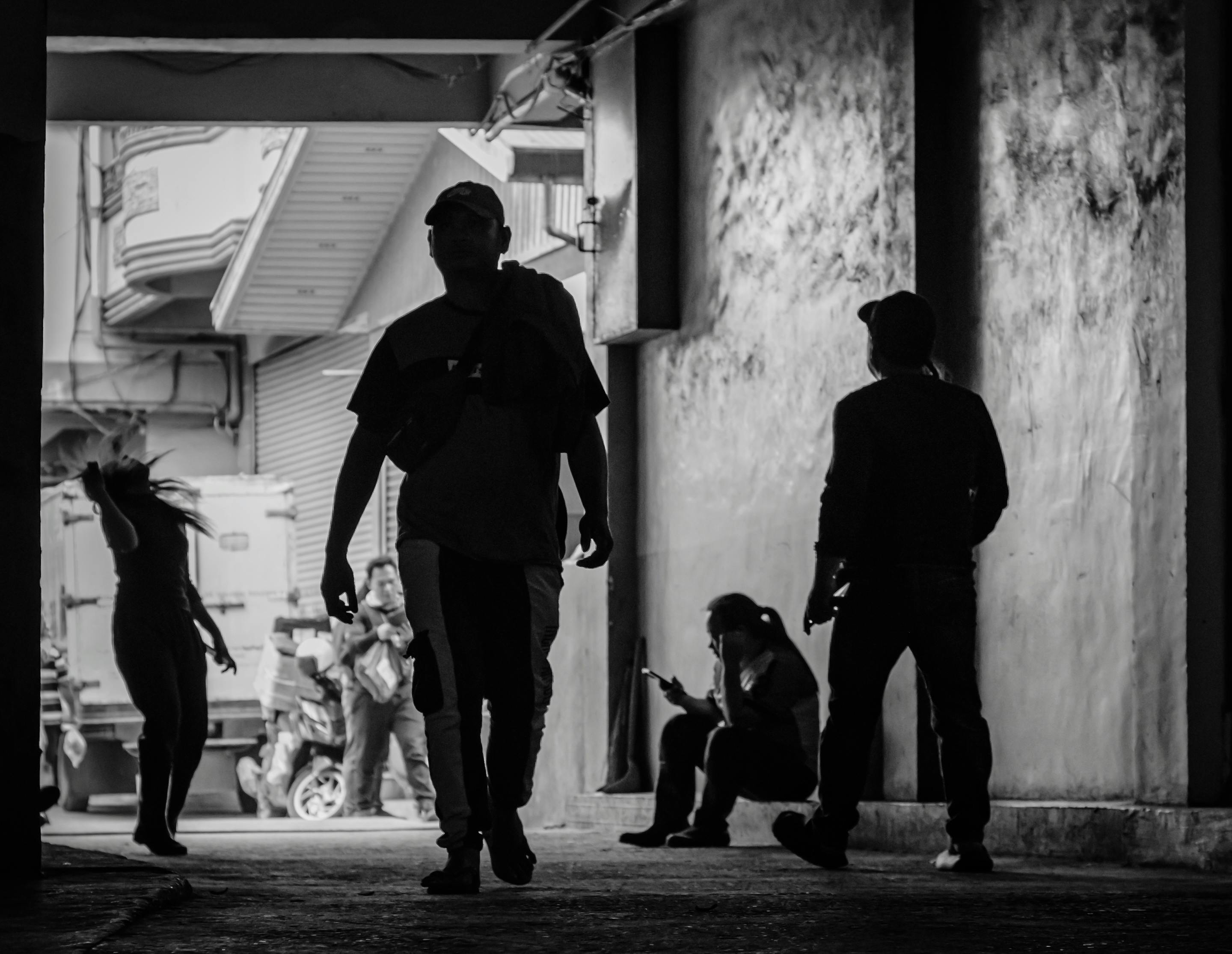 Δωρεάν Ασπρόμαυρη σιλουέτα ατόμων που περπατούν και ξεκουράζονται σε ένα αστικό σοκάκι. Φωτογραφία από στοκ φωτογραφιών