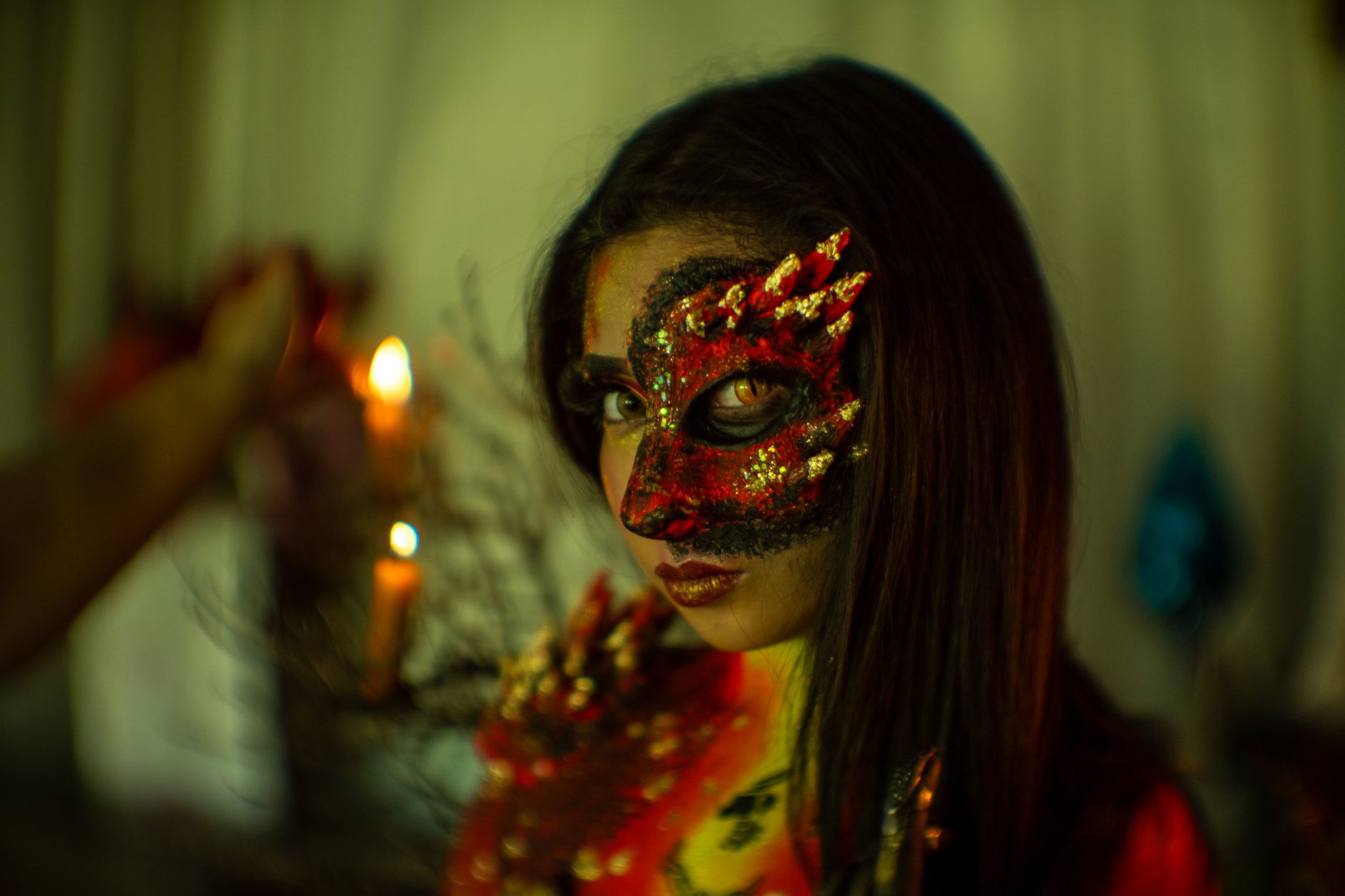 Close-up of a woman in a dragon-inspired Halloween costume, featuring detailed makeup and props.