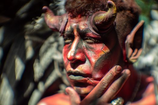 Close-up portrait of a person with dramatic devil makeup and vintage look in Mexico City.