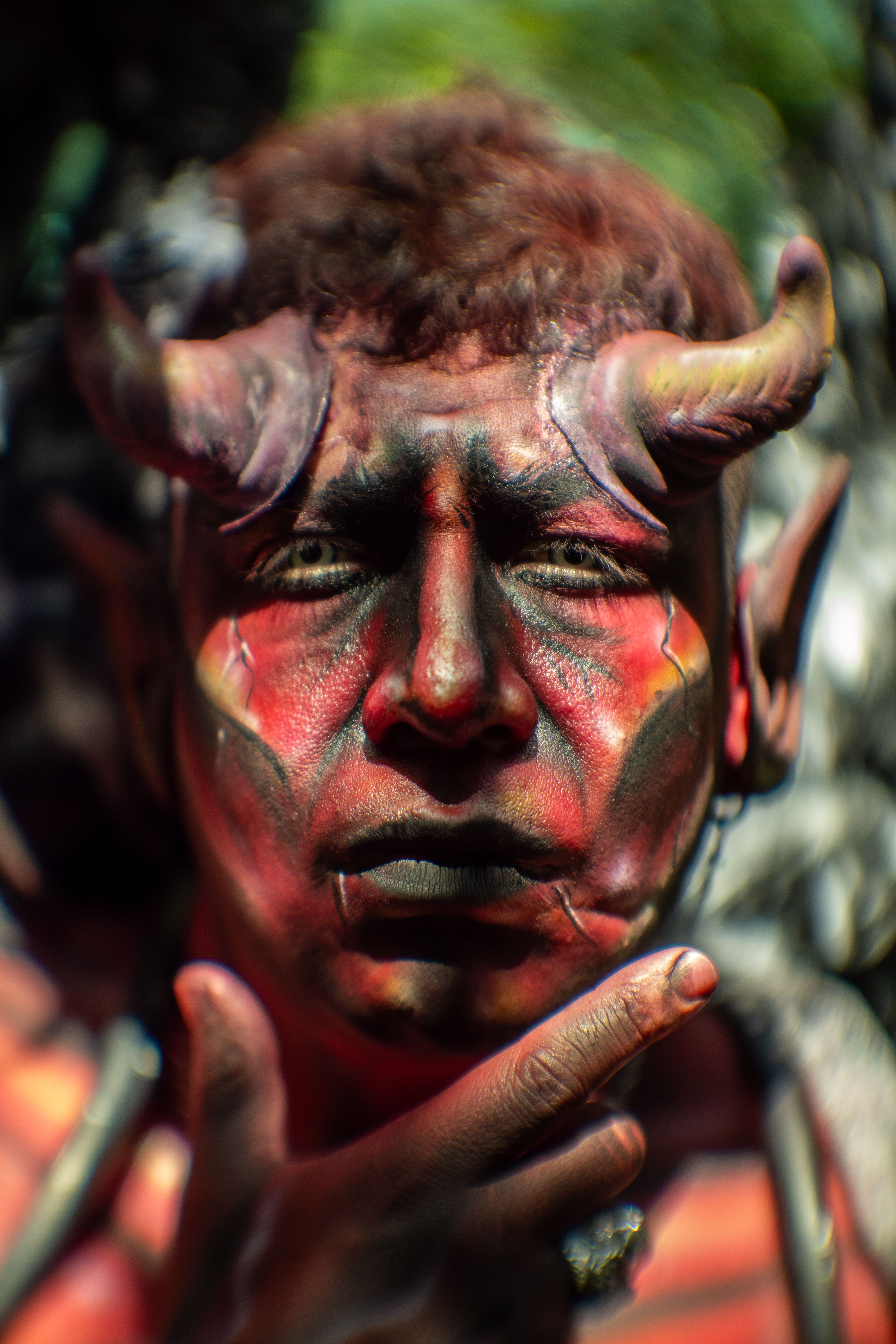 Close-up portrait of a person with elaborate demon makeup and horns, perfect for Halloween themes.