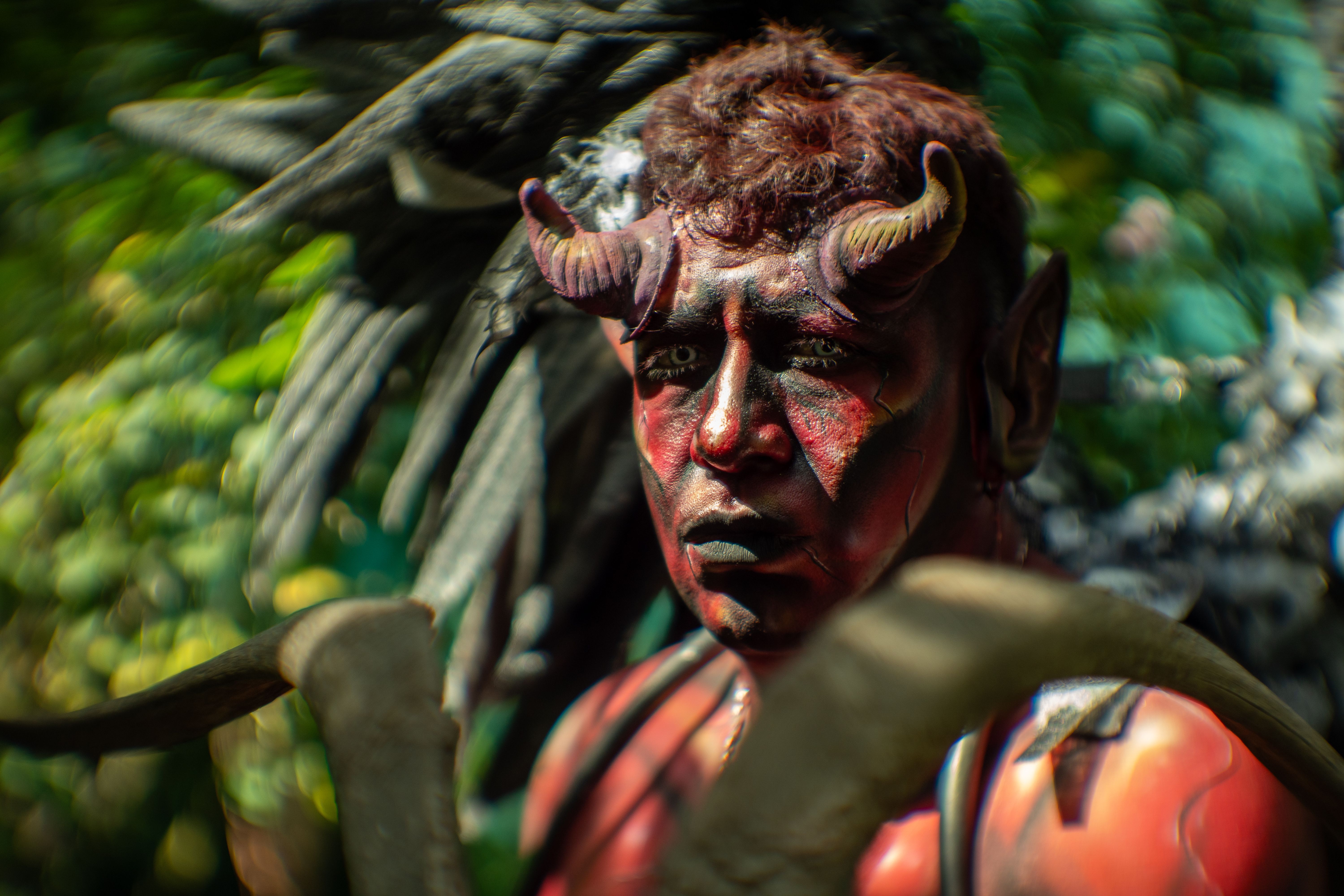 Close-up of a person in a striking devil costume outdoors in Mexico City, showcasing vivid makeup and theatrical elements.