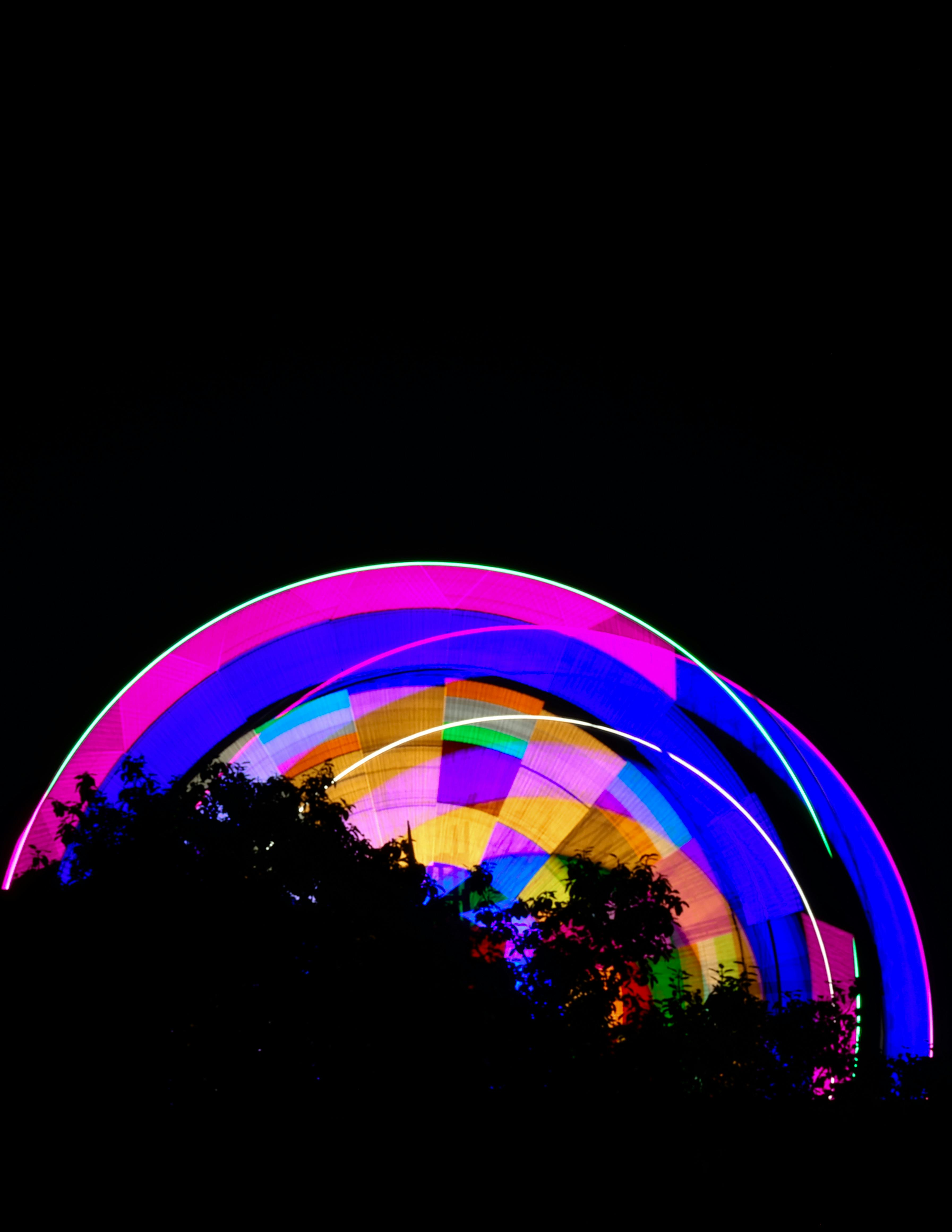 Gratuit Roată Ferris vibrantă iluminată pe un cer nocturn cu siluete de copaci în India. Fotografie de stoc