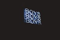 在黑暗的背景上，一个凉爽的蓝色霓虹灯标志多次显示“男孩”字样