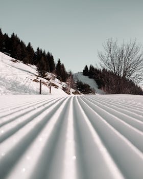 Beautiful snow-covered landscape featuring a groomed path through snowy hills and trees.
