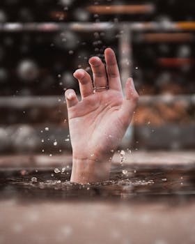 一只手从水中伸出，周围气泡环绕，营造出紧迫感