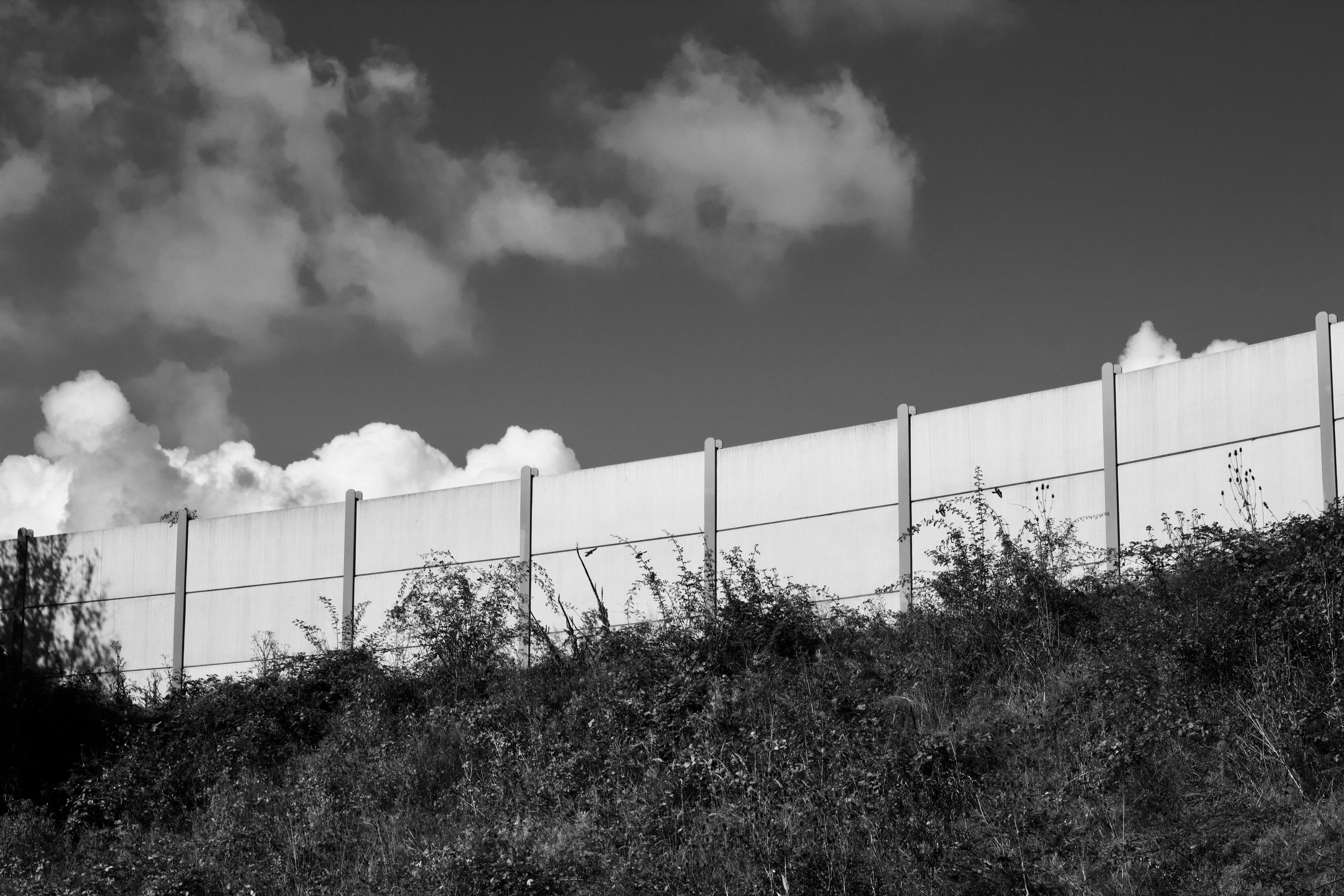 Free Monochrome image of a concrete wall under a cloudy sky, evoking a minimalist feeling. Stock Photo