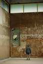 Man Observing Artwork in Abandoned Urban Space