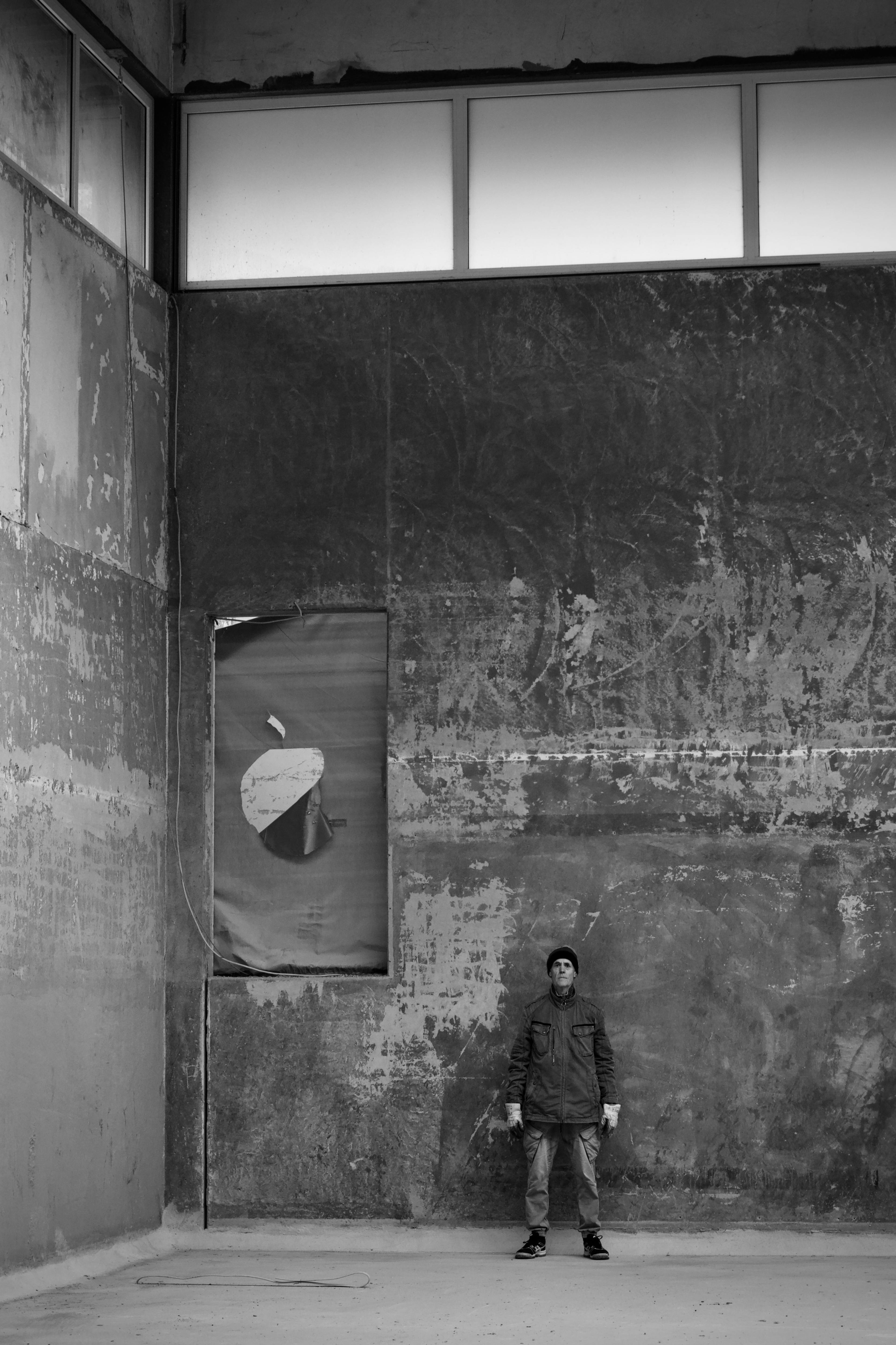 Gratuit Image en noir et blanc d'une personne dans un bâtiment industriel vide et délabré. Photos