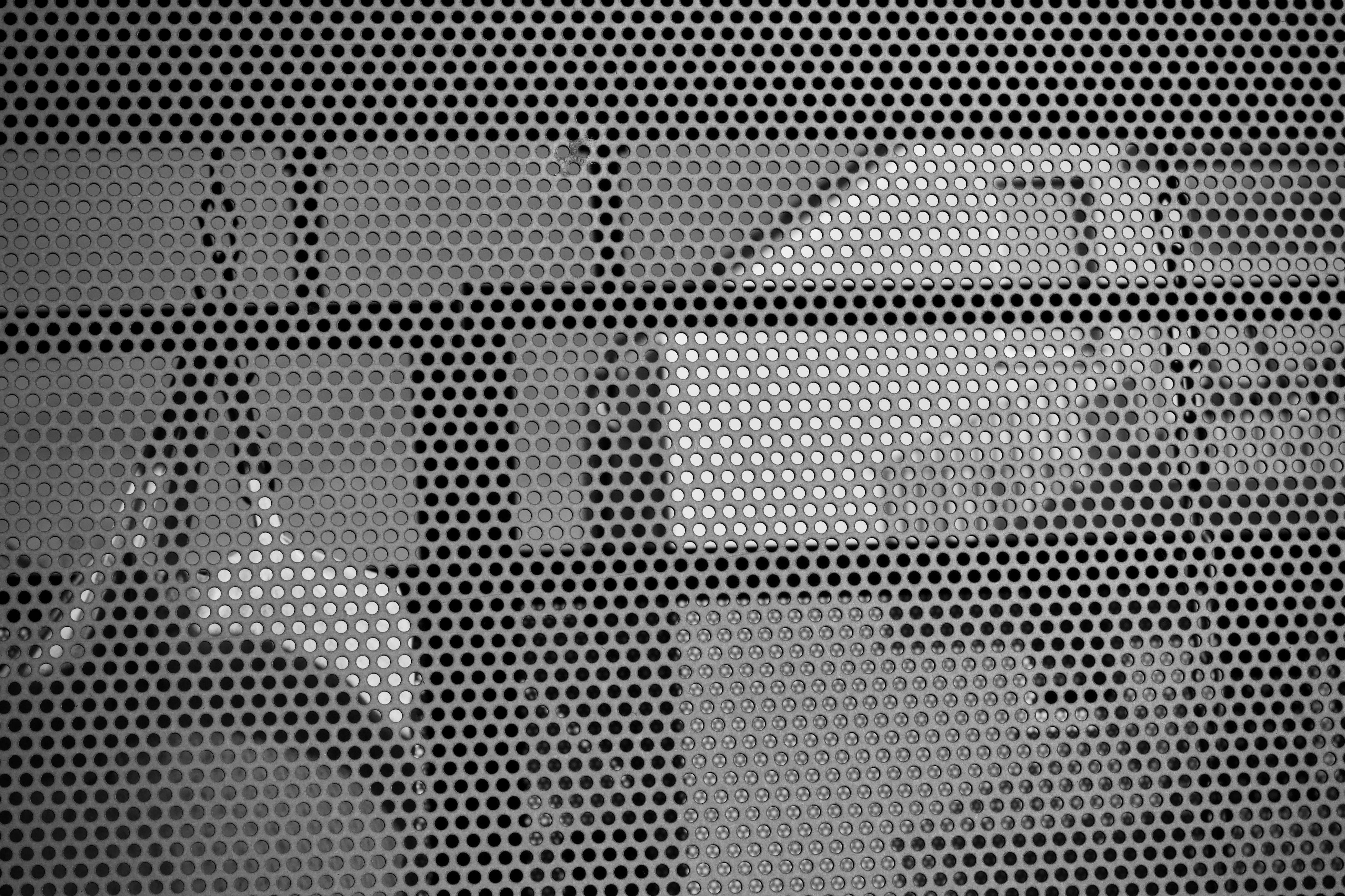 Free Black and white abstract image showing shadows through a perforated metal screen. Stock Photo