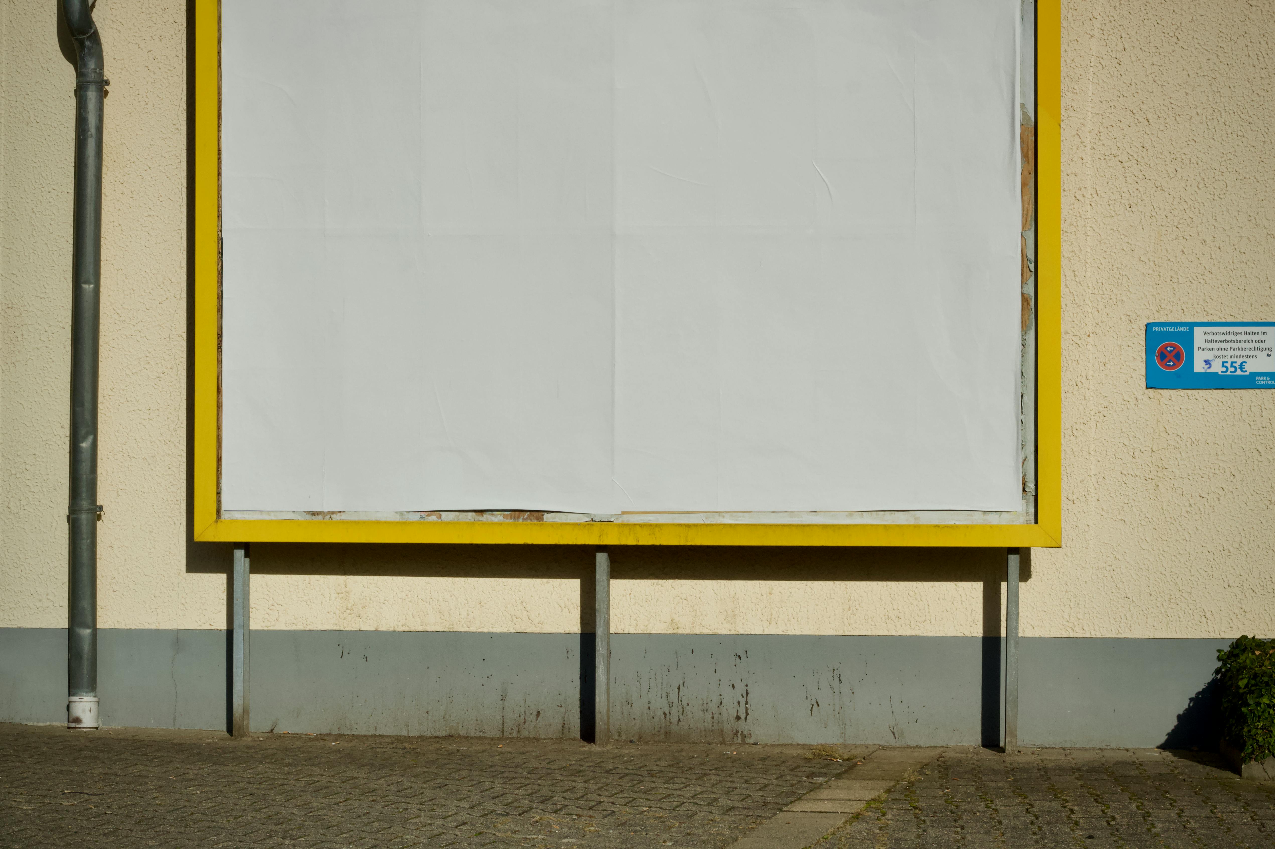 ฟรี ป้ายโฆษณาเปล่าบนถนนที่มีกรอบสีเหลือง เหมาะสำหรับใช้เป็นแบบจำลองโฆษณา คลังภาพถ่าย