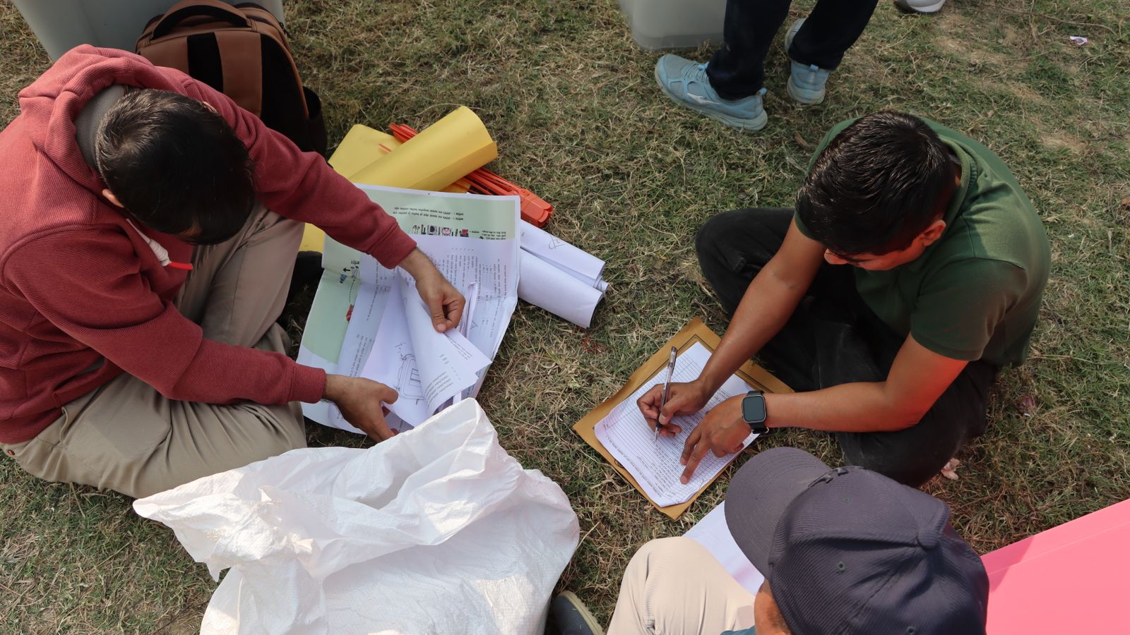 Election officials organizing ballots in an outdoor setting in Nepal, highlighting the electoral process.