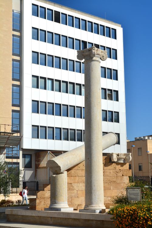 Free Ancient Roman columns stand in stark contrast to a modern building in Trapani, Sicily. Stock Photo