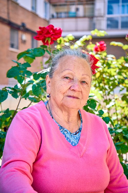 Free Portrait of a senior woman in a vibrant garden on a sunny day. Stock Photo