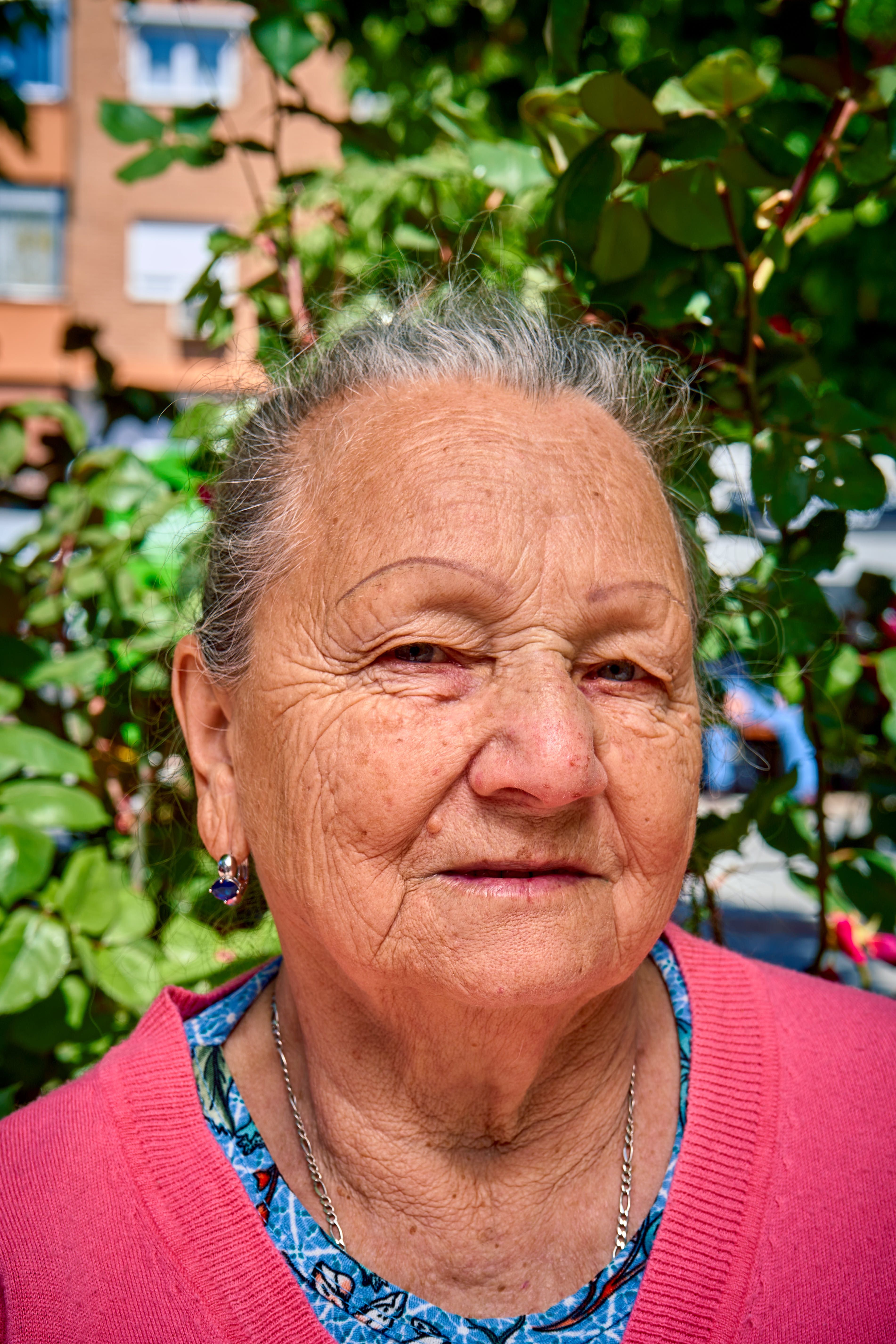 Portrait of an elderly woman outdoors in a sunny garden, Islas Baleares, Spain.