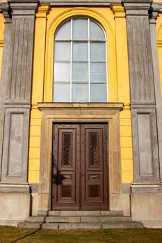 Elegant yellow and gray facade of a historic building with a wooden door in Jönköping, Sweden.