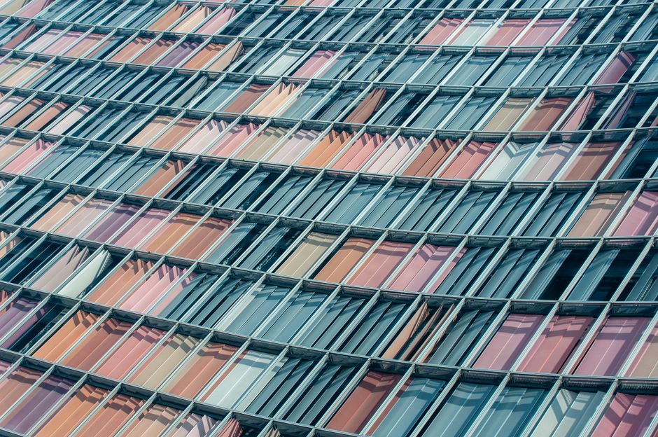 Close-up view of a geometric facade with colorful glass panels in a modern architectural design.