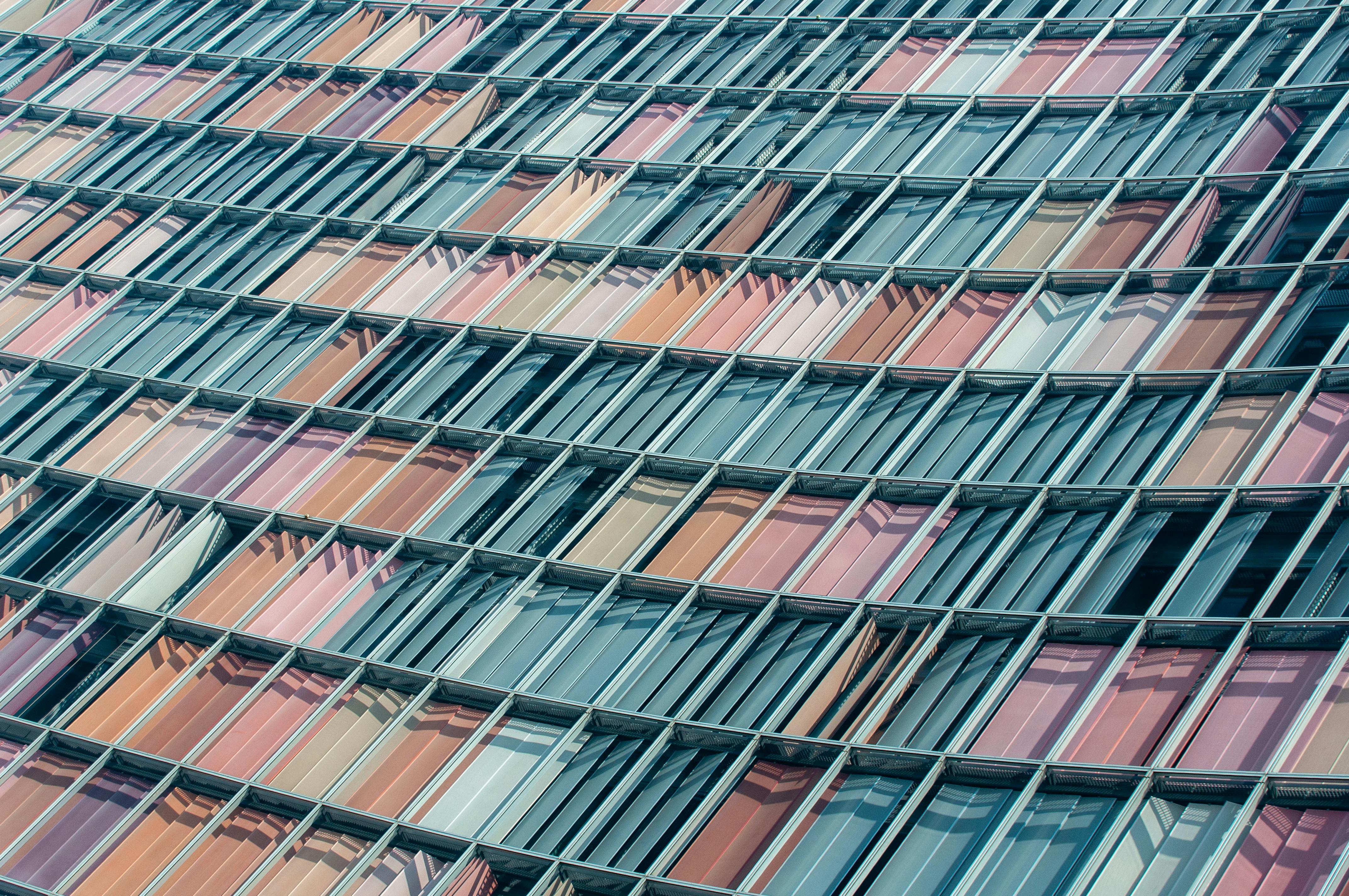 Ilmainen Lähikuva geometrisesta julkisivusta, jossa on värikkäitä lasipaneeleja modernissa arkkitehtonisessa suunnittelussa. Kuvapankkikuva