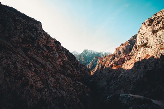 Breathtaking view of a rocky canyon with towering peaks under a clear blue sky.