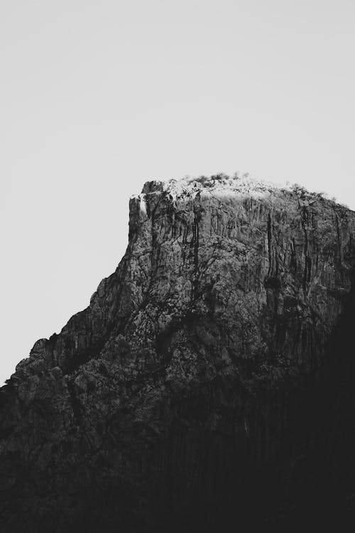 Black and white amazing scenery of rough rocky mountain slope under clear sky