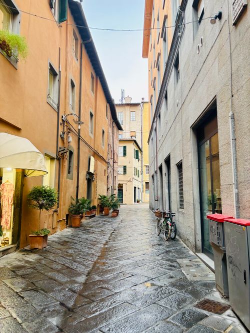Free A picturesque street in Lucca, Tuscany, Italy after rain with bicycles and shops. Stock Photo
