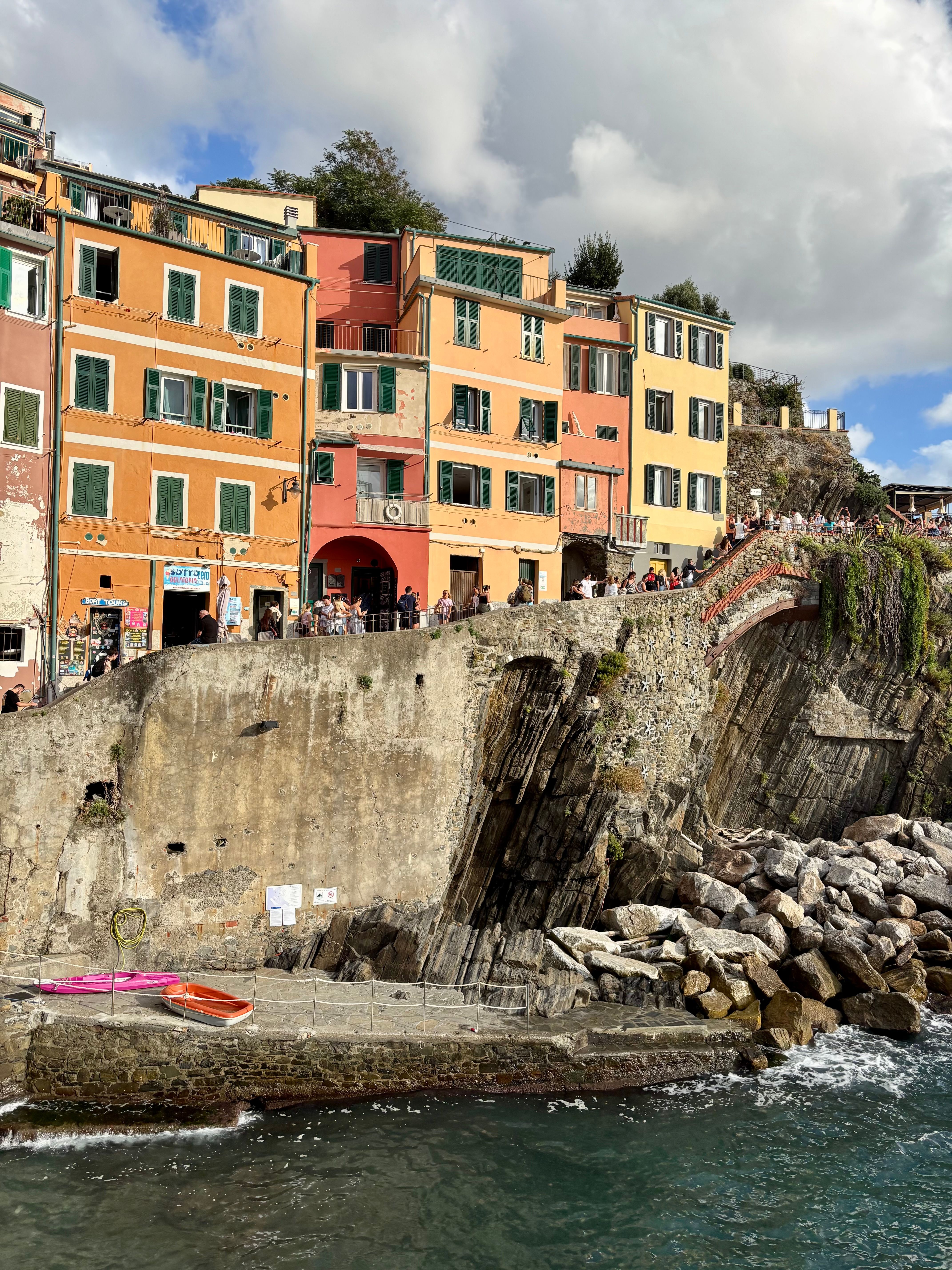 Vibrant buildings and cliffs in Riomaggiore, showcasing Italian coastal charm.