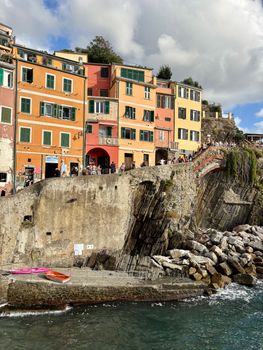 Vibrant buildings and cliffs in Riomaggiore, showcasing Italian coastal charm.