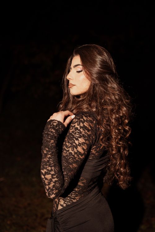 Free Portrait of an elegant woman in a black lace dress at night, capturing a sophisticated and artistic vibe. Stock Photo