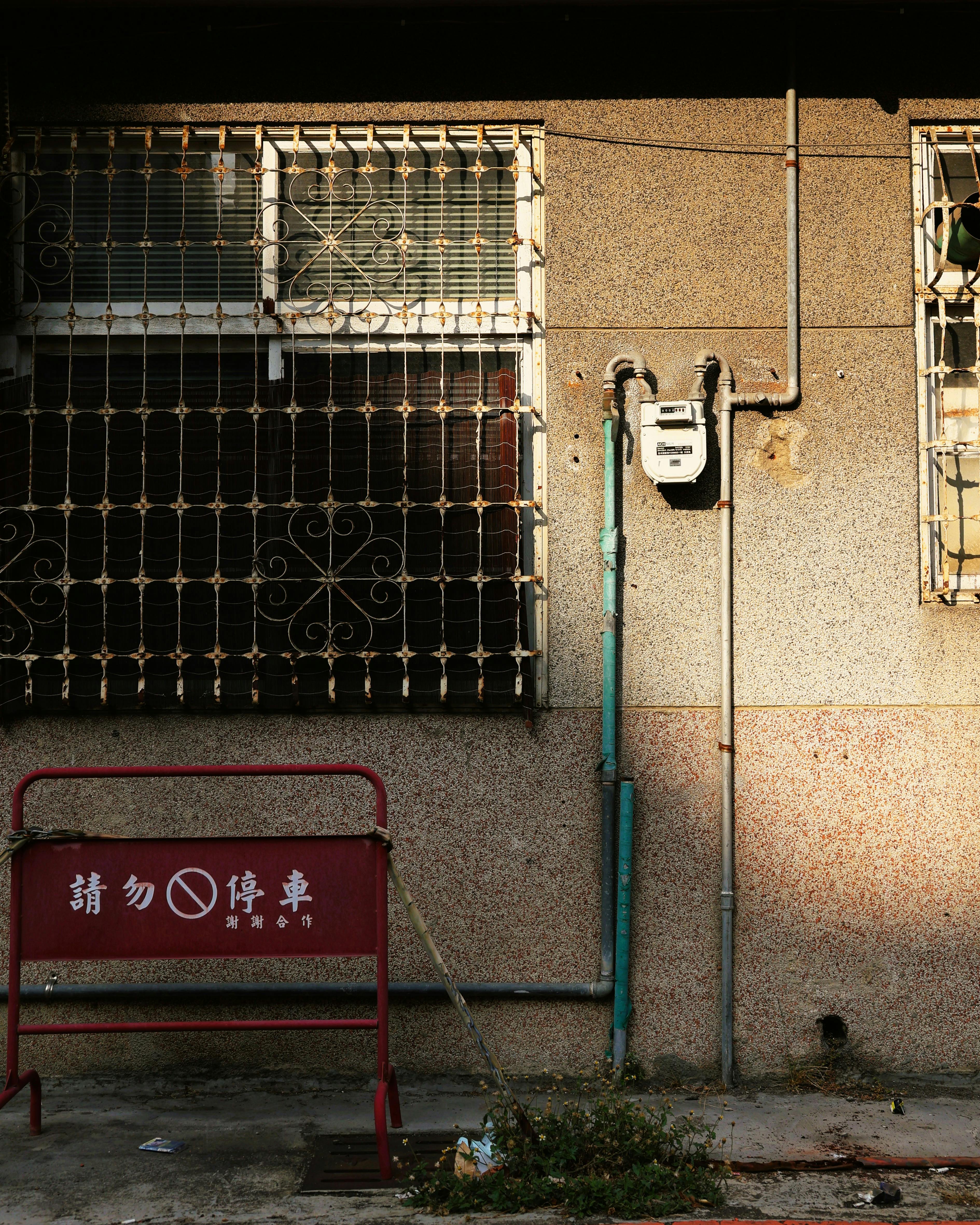 grátis Exterior de um prédio urbano com janelas gradeadas e medidores de serviços públicos. Foto profissional