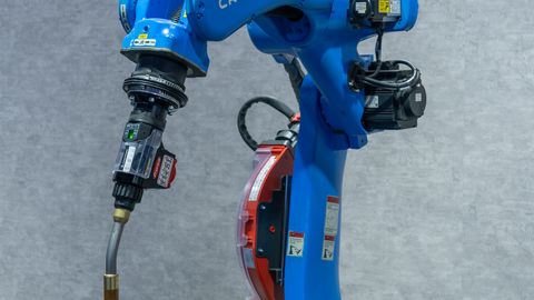 Industrial robotic welding station featuring a blue robot arm welding a metal object.