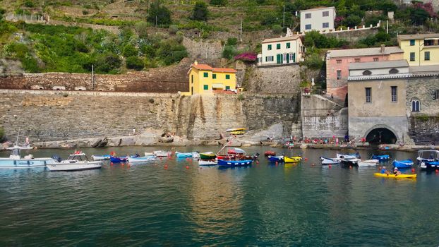 Scenic view of colorful boats and houses in Vernazza, a coastal village in Liguria, Italy.