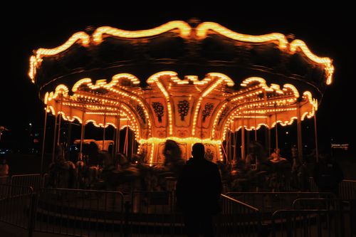 Free A beautifully lit carousel spinning at night, creating a vibrant and magical atmosphere. Stock Photo