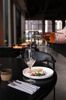 A stylish restaurant scene with gourmet dish and wine pour, perfect for lifestyle imagery.