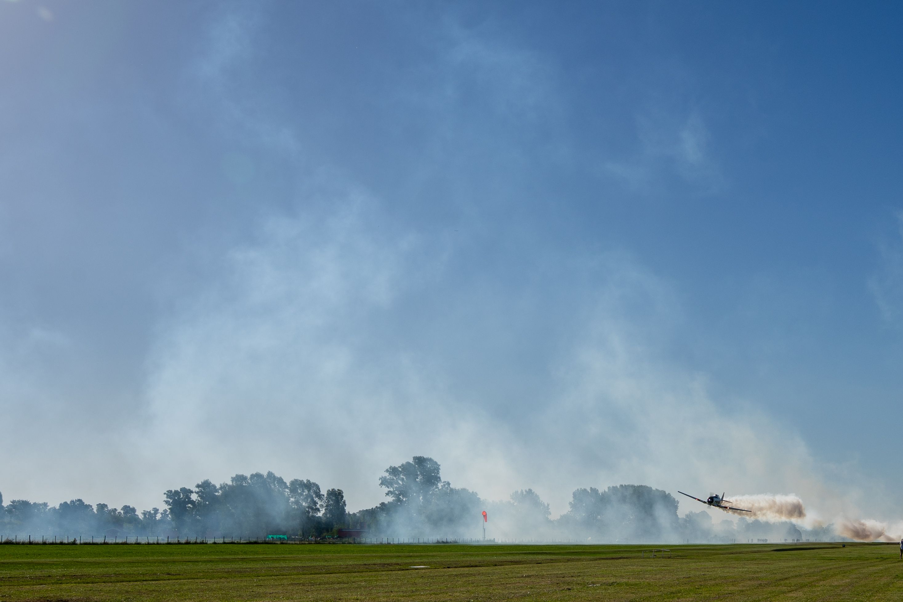 Dynamic stunt plane performing aerial acrobatics over a field in General Rodríguez, Argentina.