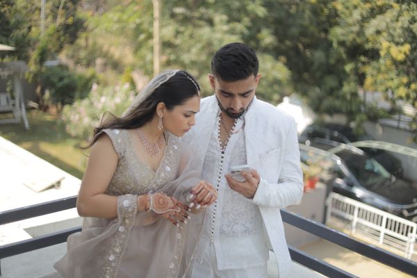 Indian bride and groom sharing a candid outdoor wedding moment