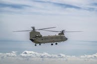 Military Helicopter Flying Above the Clouds