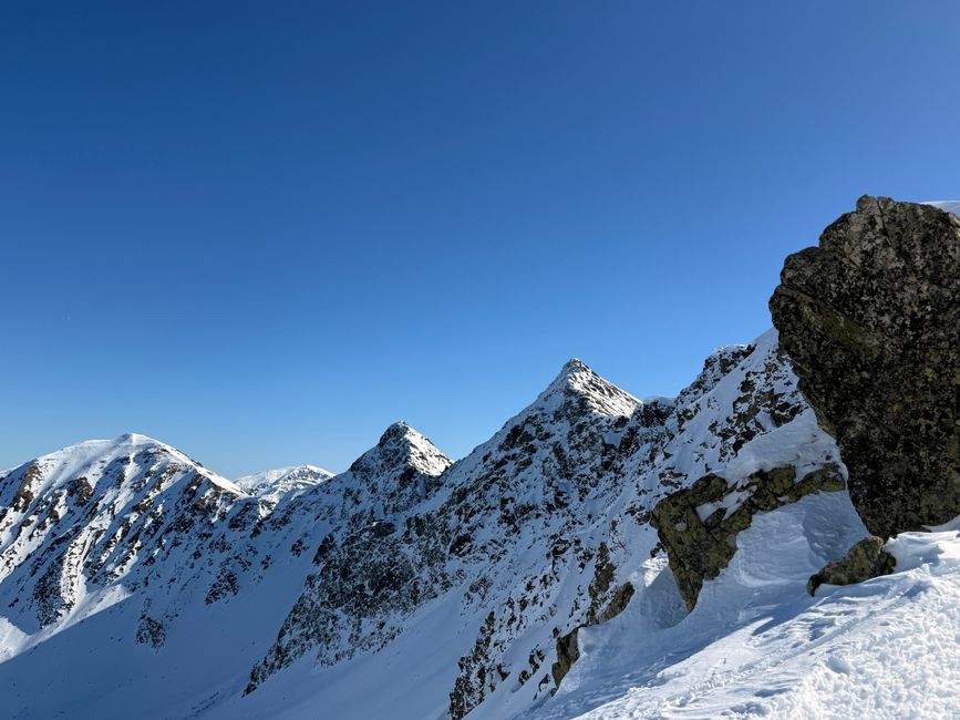 Breathtaking view of snow-covered High Tatra Mountains under a clear blue sky.
