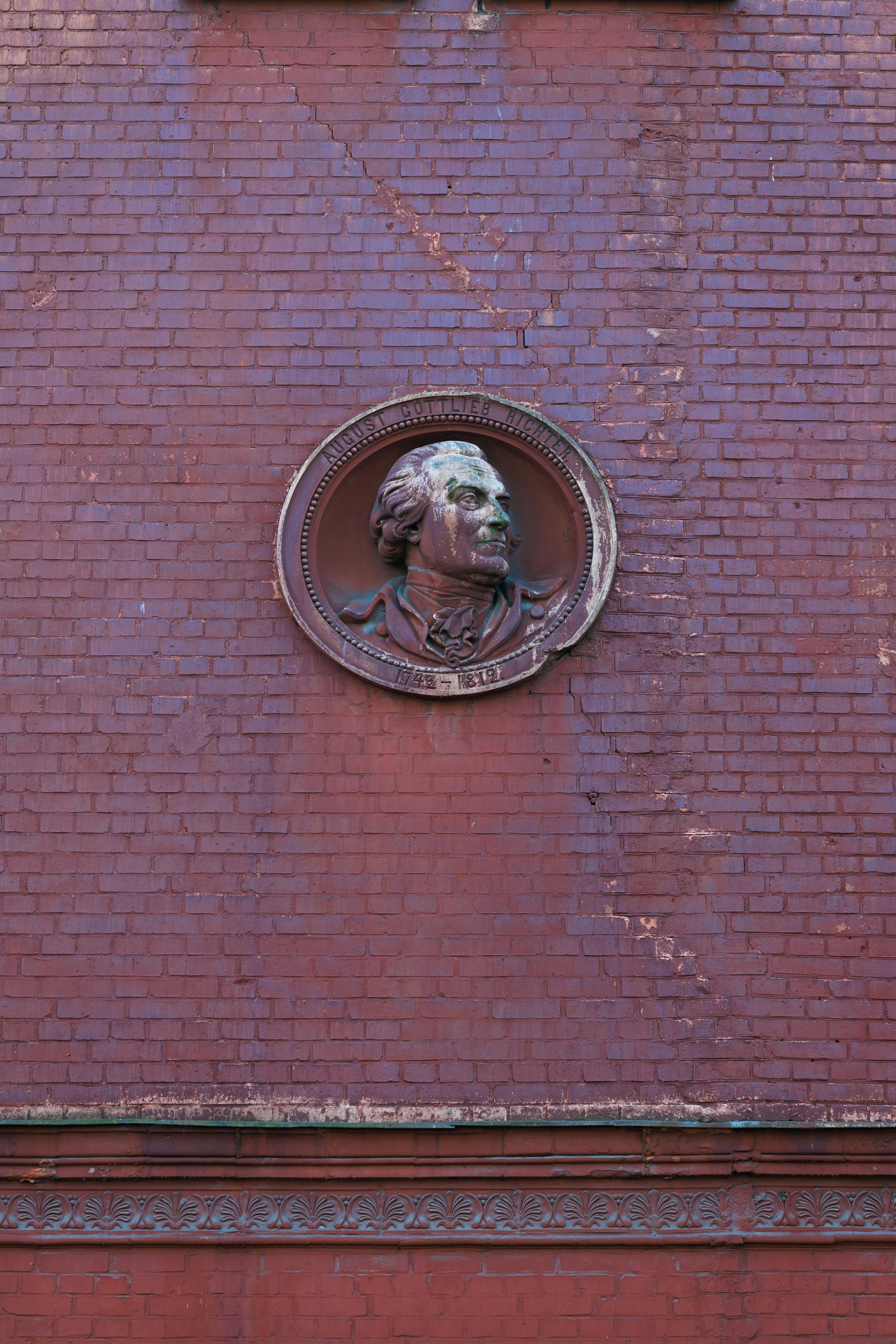 De franc Un medalló vintage en una paret de maó vermell a Kaliningrad, que mostra arquitectura clàssica. Foto d'estoc
