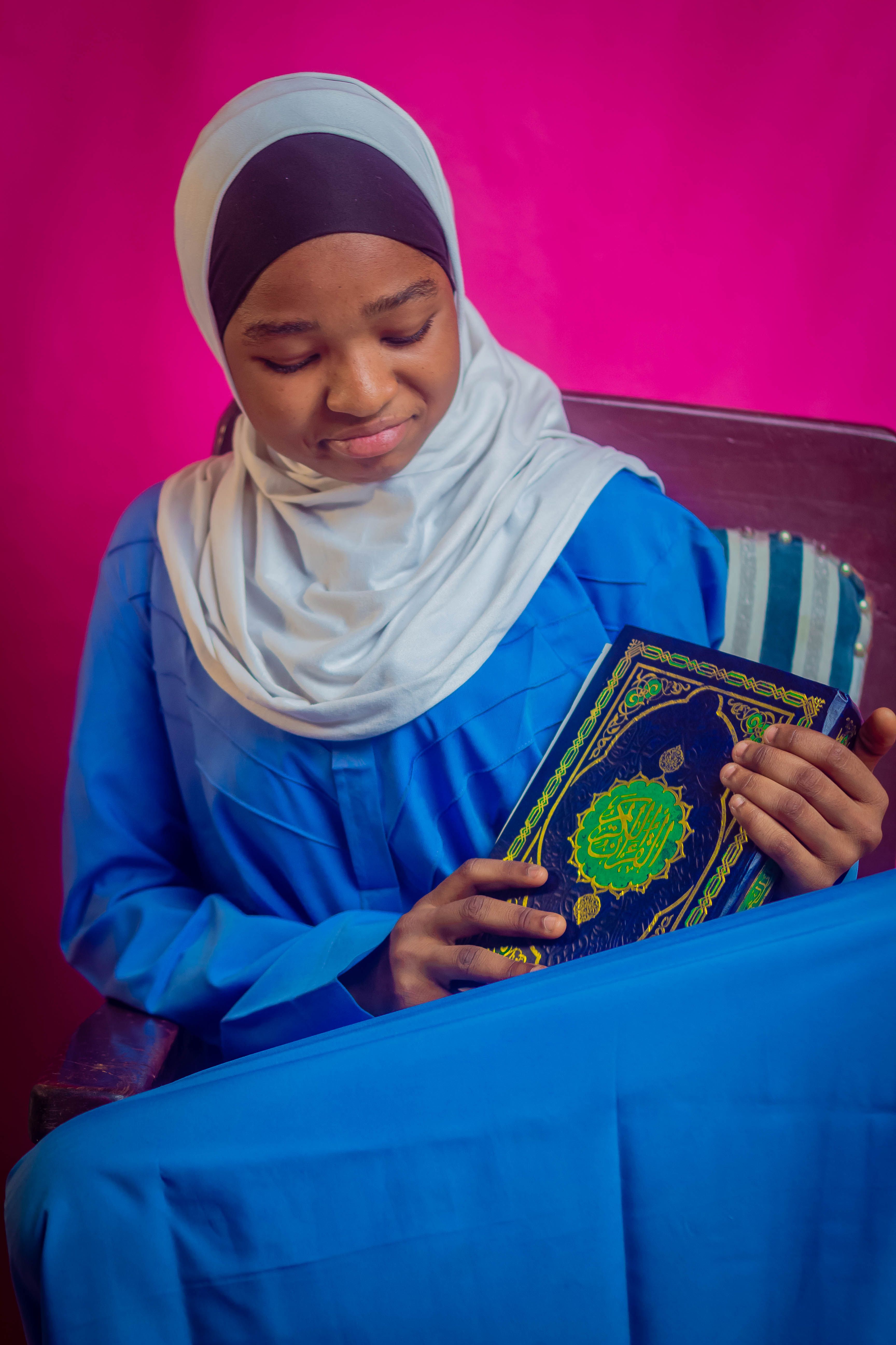 Young Muslim woman in headscarf holding the Quran