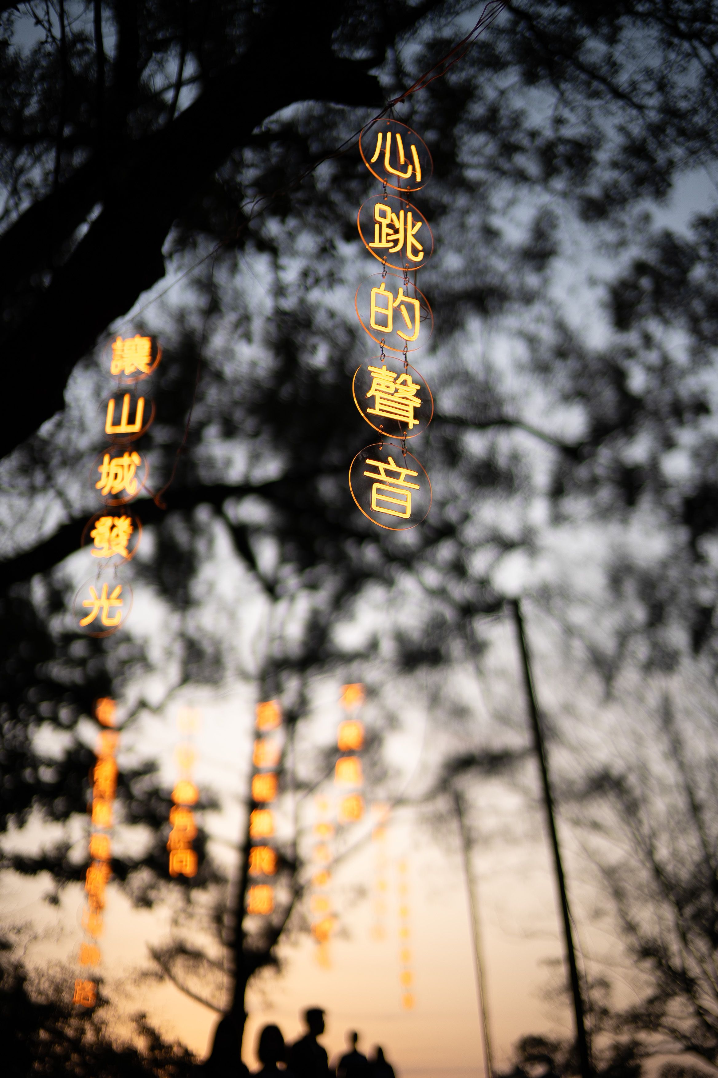 Tree Silhouette With Neon Sign at Twilight Taiwan 4K iPhone 17 Wallpaper
