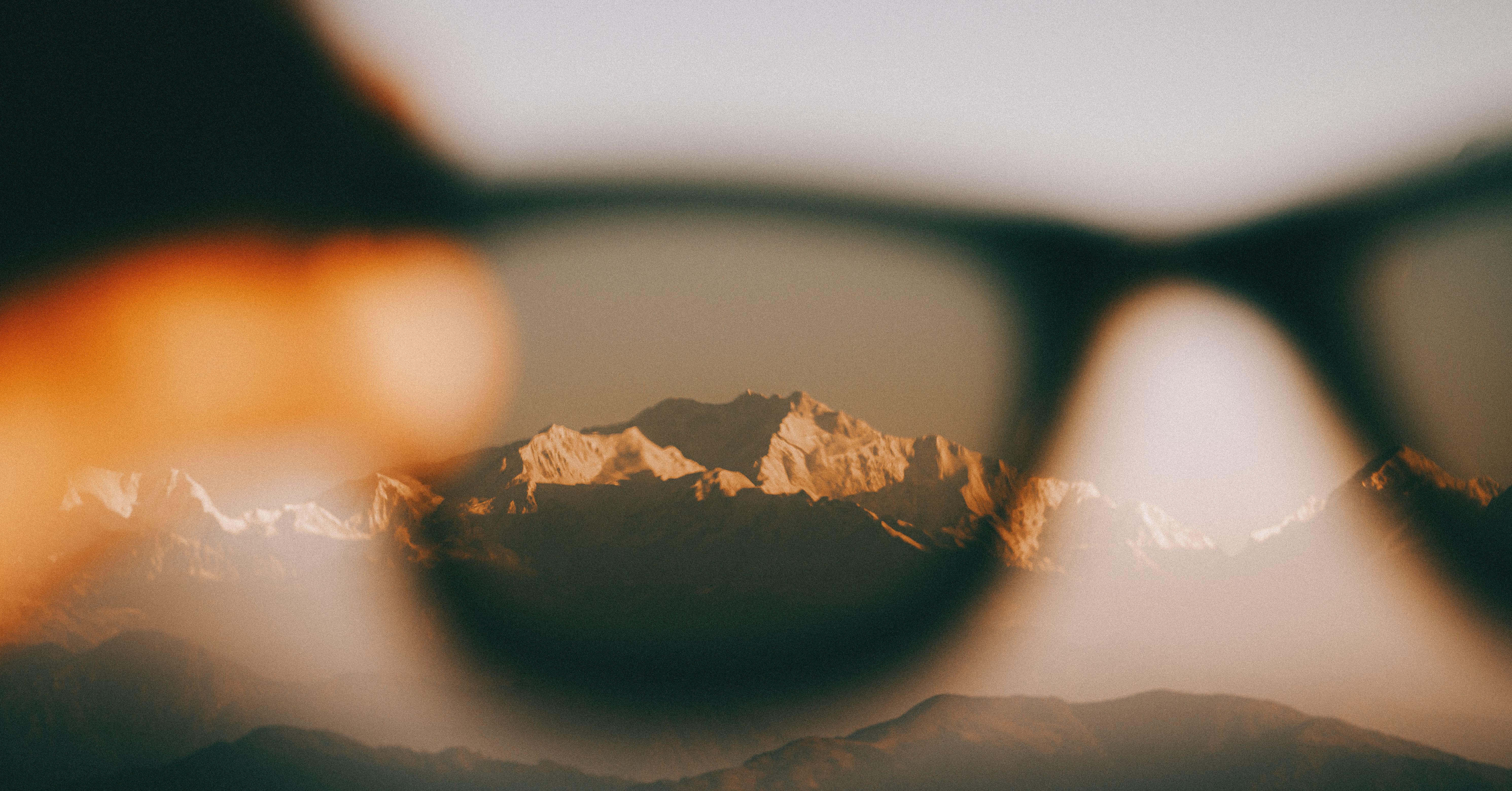 A stunning mountain range seen through sunglasses, highlighting natural beauty.