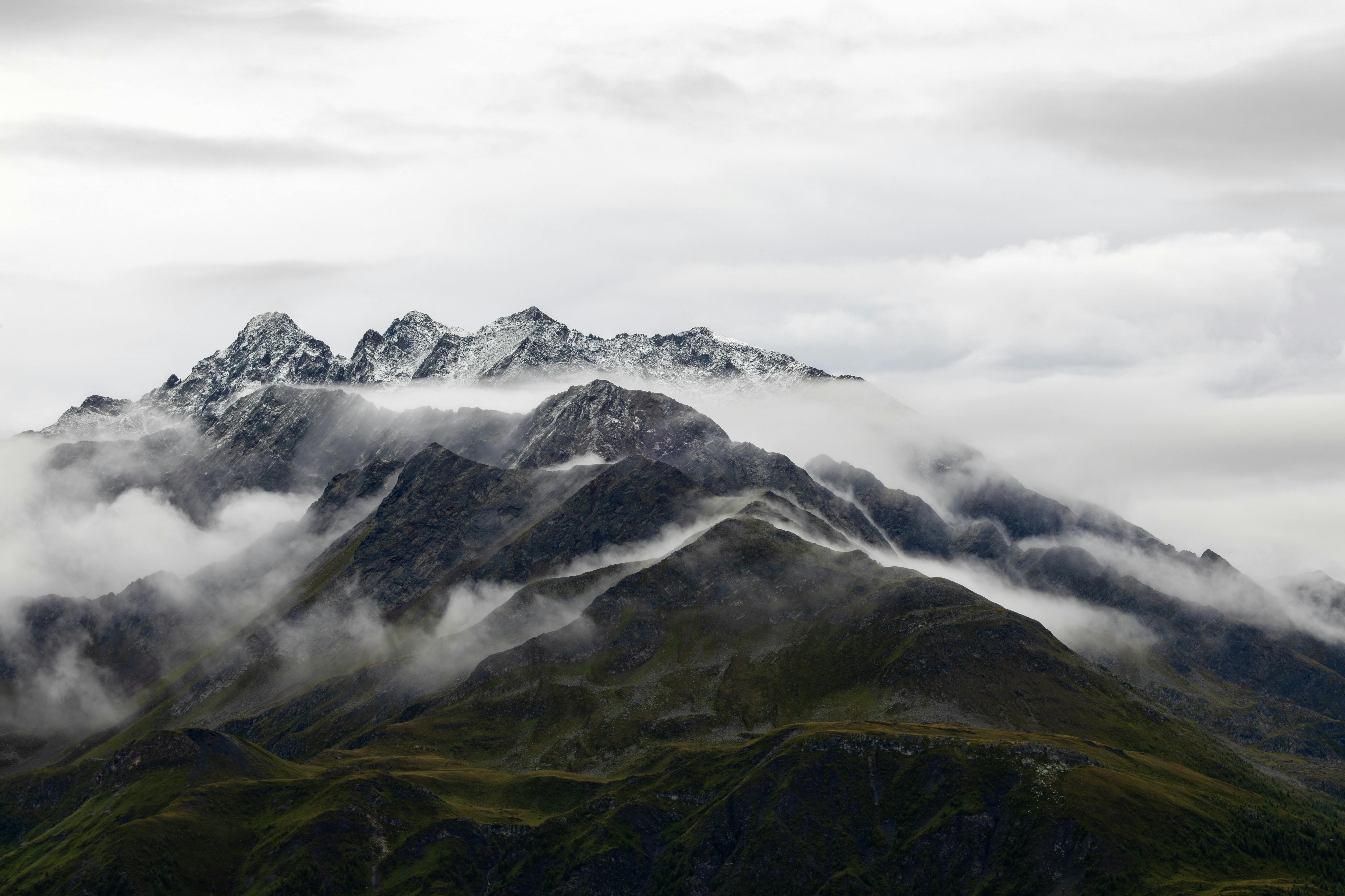 Gratis Vista spettacolare delle Alpi innevate avvolte dalle nuvole a Korutany, in Austria. Foto a disposizione