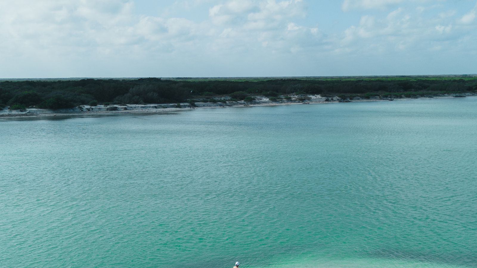 A solitary sandbank surrounded by shallow turquoise water